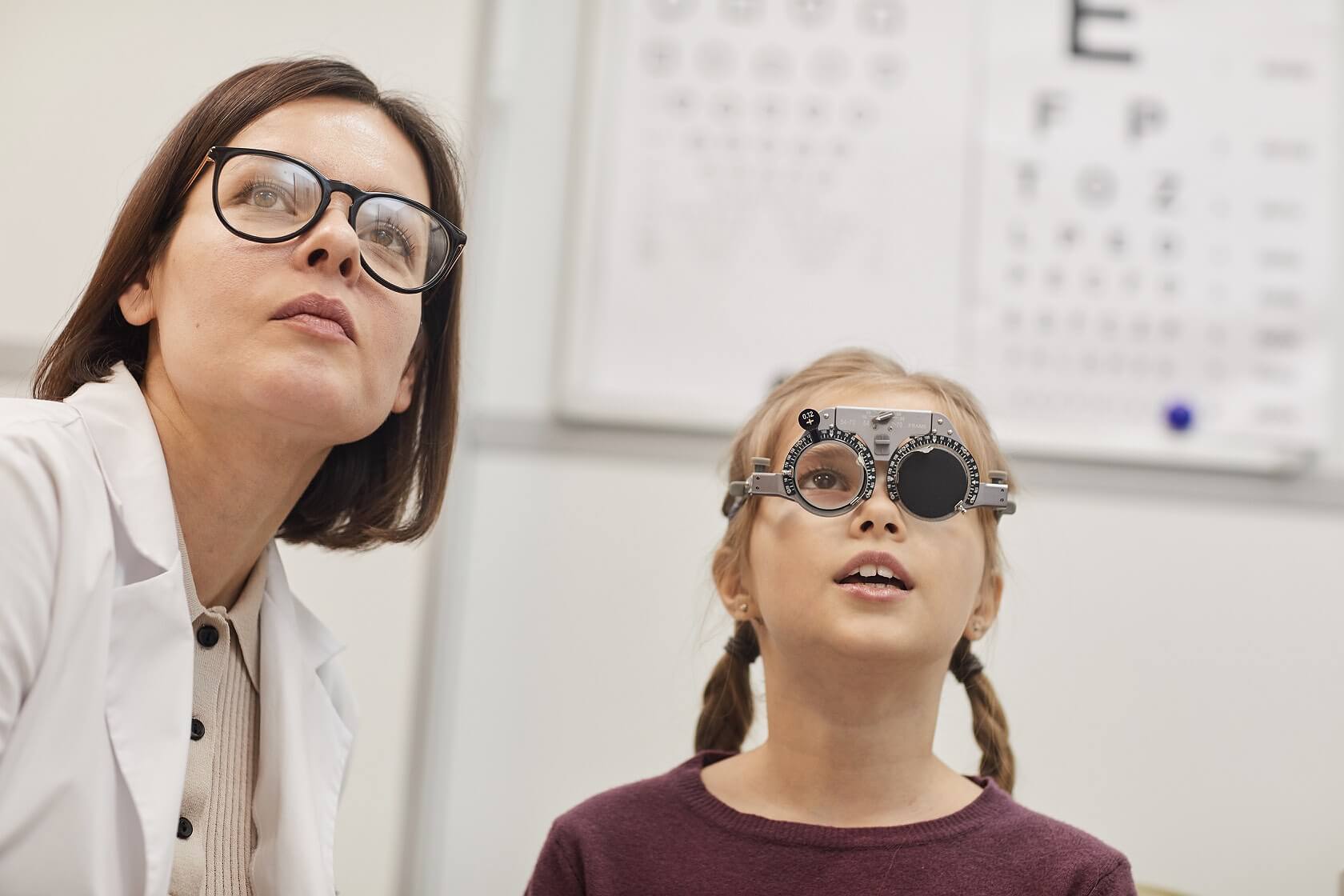 Eye Doctor and patient both looking at an eyechart